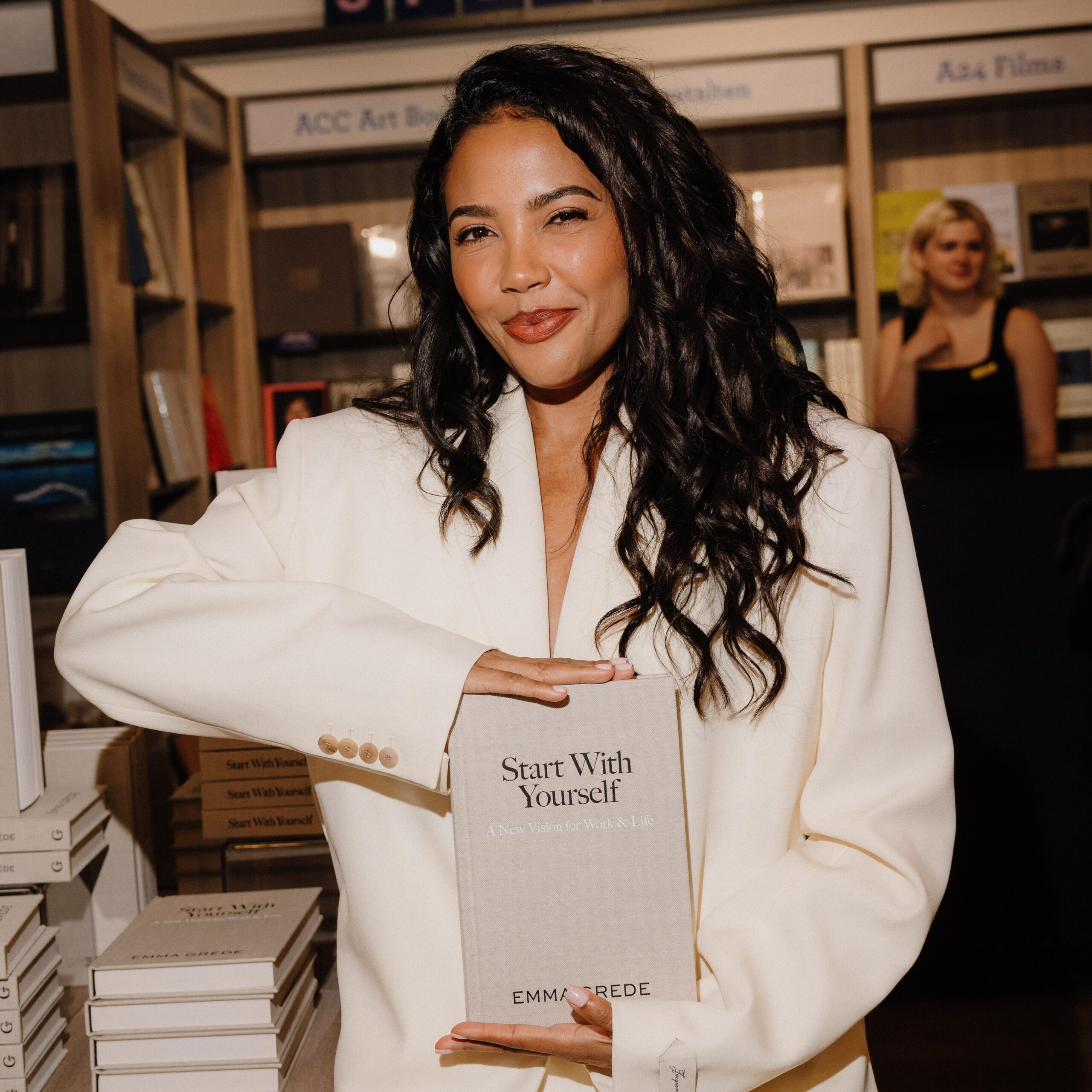 Emma Grede holding her book "Start With Yourself"