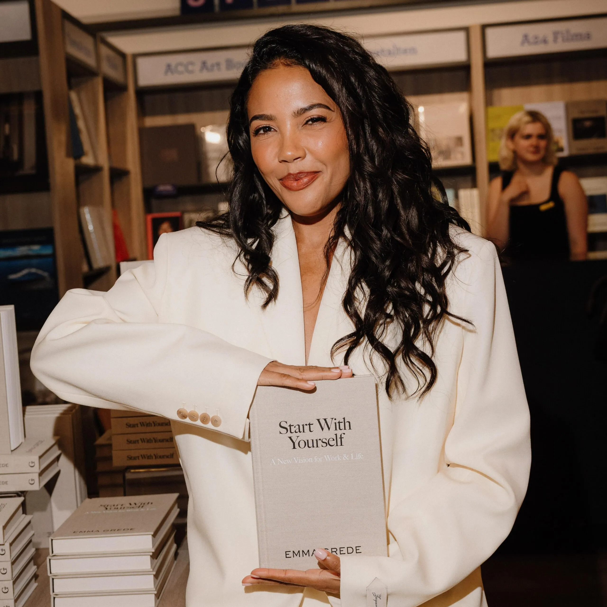 Emma Grede holding her book "Start With Yourself"