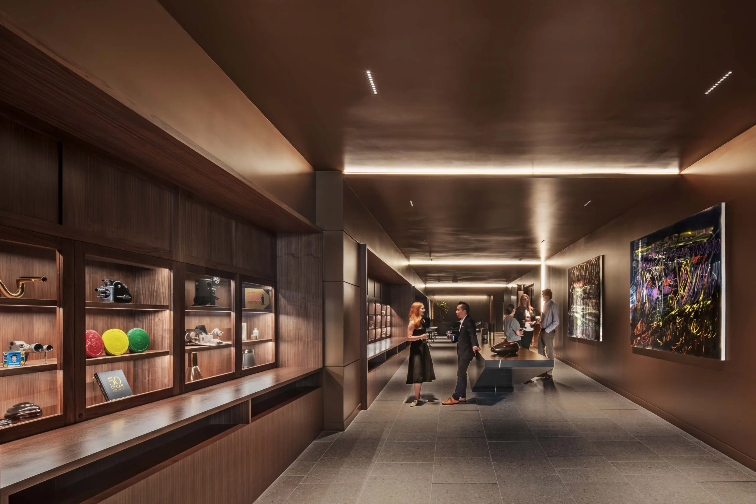 Chaplin Theater's new long reception lobby as guests schmooze with drinks alongside glass cases full of movie memorabilia.
